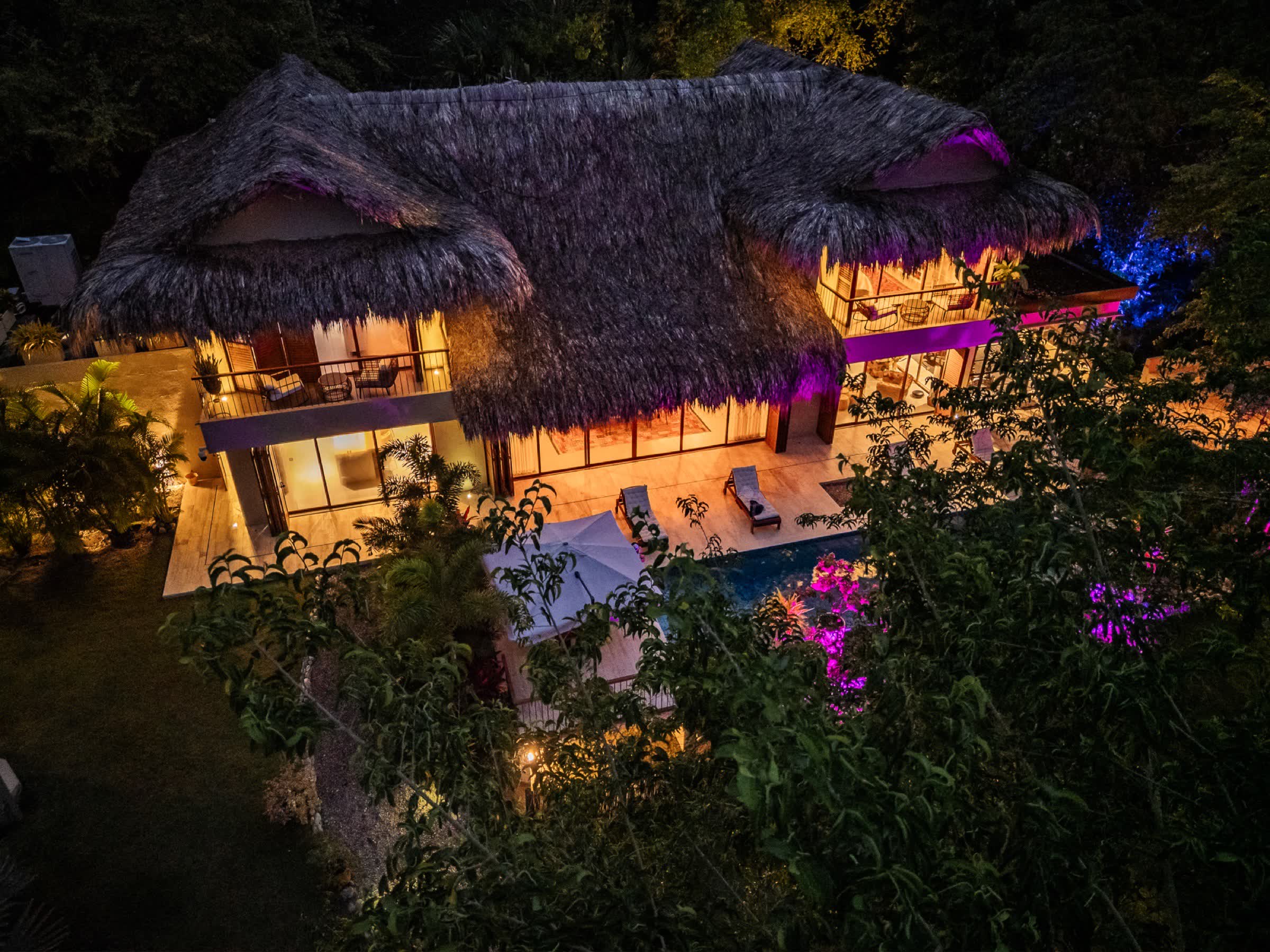 The villa glowing at dusk, seen from above