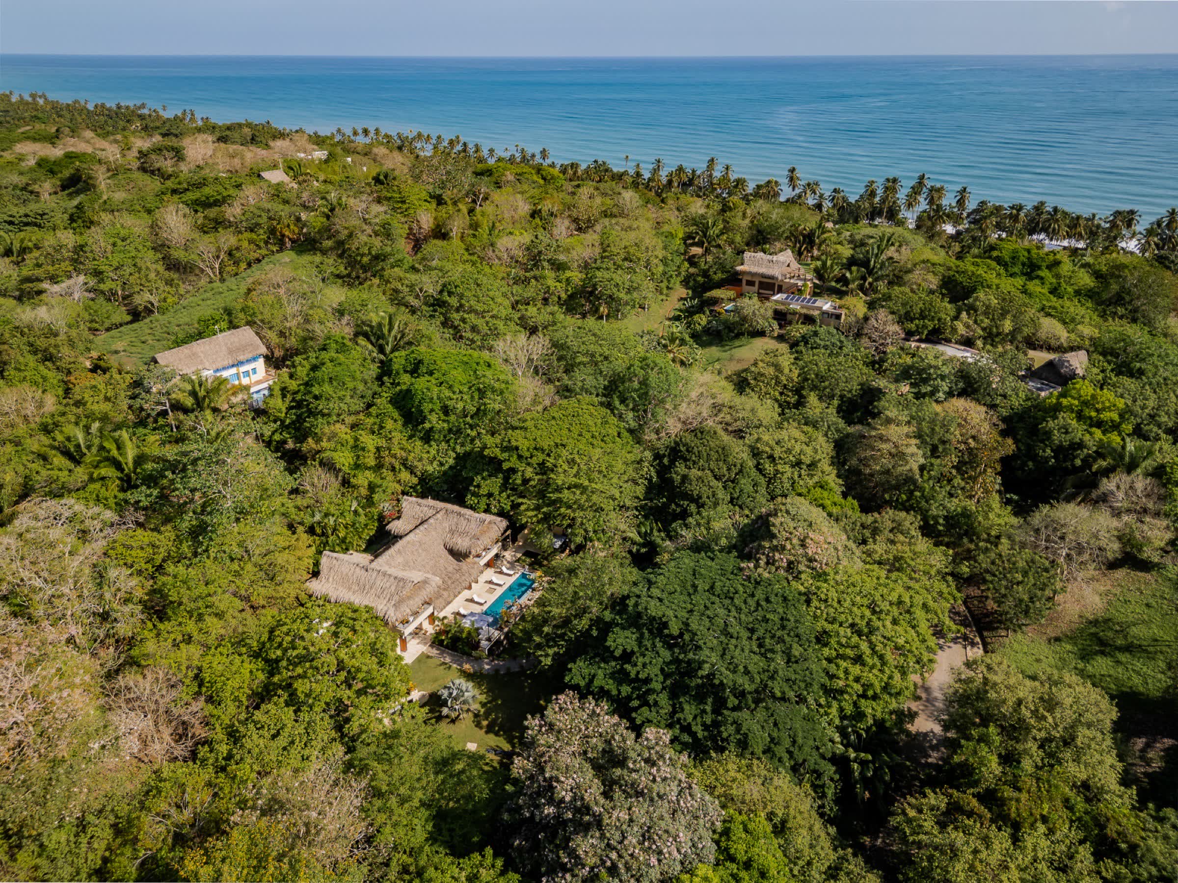 Aerial view of the villa in the jungle with the Caribbean Sea beyond